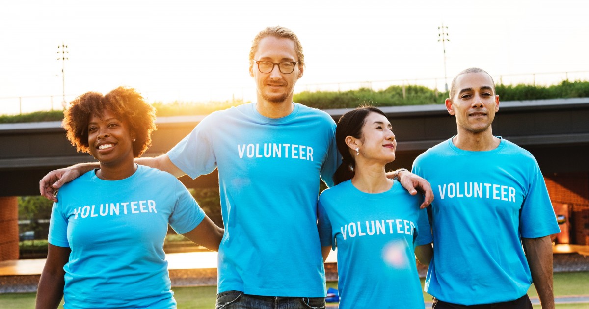 Volunteers standing side by side and smiling