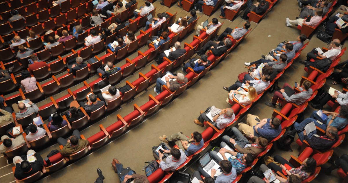 A large meeting hall with many attendees